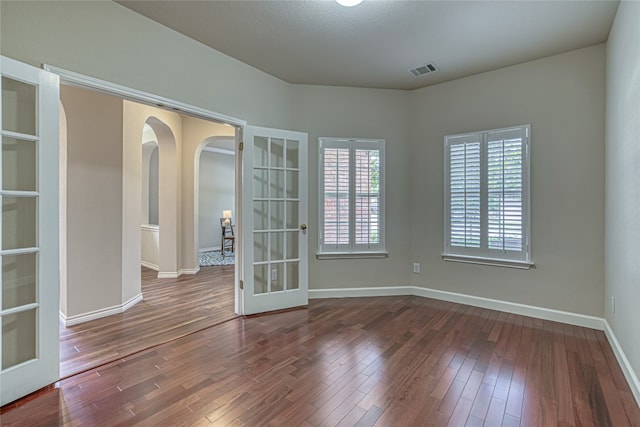 empty room featuring dark hardwood / wood-style floors and french doors