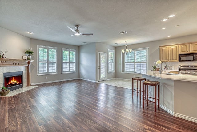 kitchen featuring a breakfast bar, dark hardwood / wood-style floors, tasteful backsplash, sink, and stainless steel range