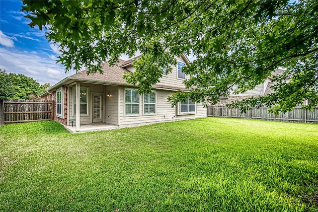 back of property with a yard and a patio