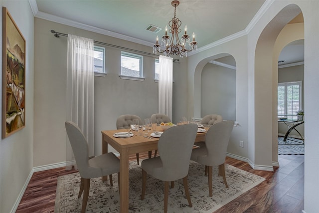 dining space with crown molding, dark hardwood / wood-style flooring, and a chandelier