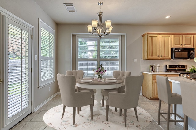 dining area featuring light tile patterned floors and an inviting chandelier