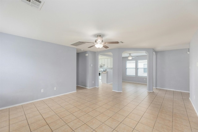 tiled spare room featuring ceiling fan