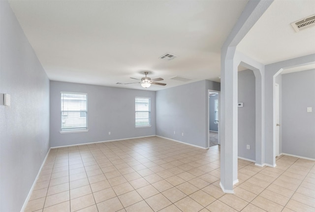 tiled empty room with ceiling fan and a wealth of natural light