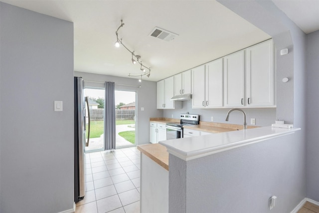 kitchen featuring kitchen peninsula, light tile patterned floors, appliances with stainless steel finishes, and white cabinetry