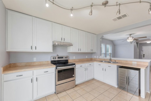 kitchen featuring stainless steel electric stove, beverage cooler, sink, white cabinetry, and ceiling fan