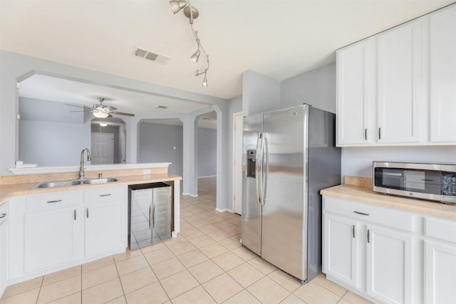 kitchen with white cabinetry, light tile patterned floors, stainless steel appliances, sink, and ceiling fan