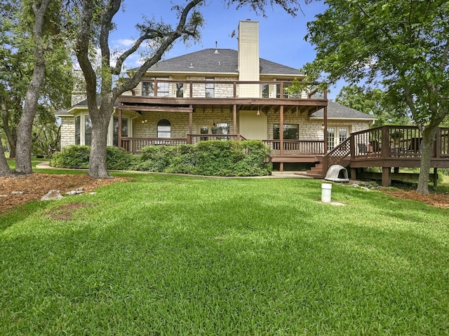 rear view of property featuring a lawn and a deck