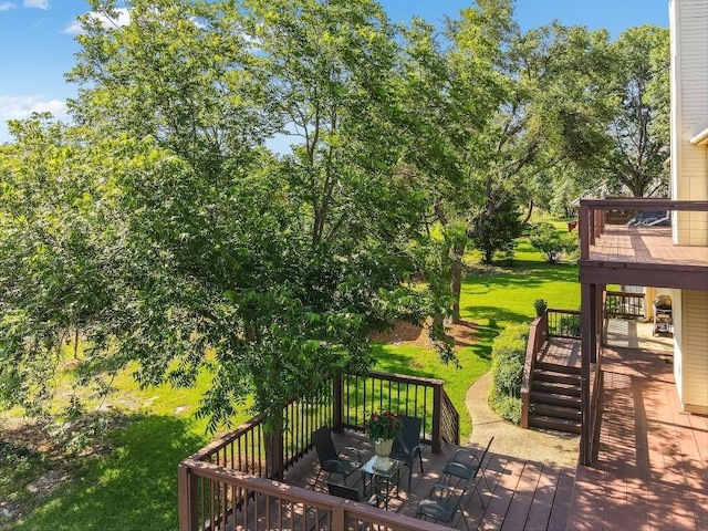 wooden terrace featuring outdoor dining area and a yard