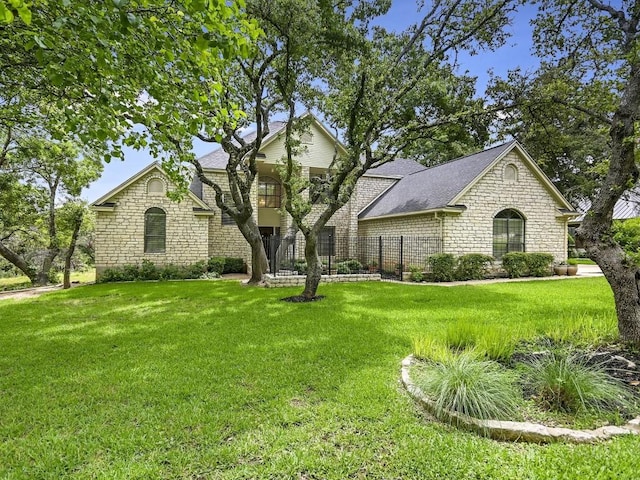 view of front of house with a front yard, stone siding, and roof with shingles