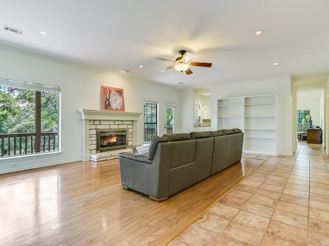 living room with visible vents, recessed lighting, a fireplace, ceiling fan, and light wood-style floors