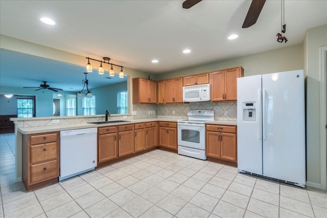 kitchen with ceiling fan, white appliances, kitchen peninsula, and sink