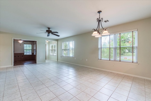 tiled empty room featuring ceiling fan and a healthy amount of sunlight