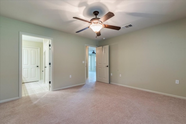 spare room with ceiling fan and light carpet