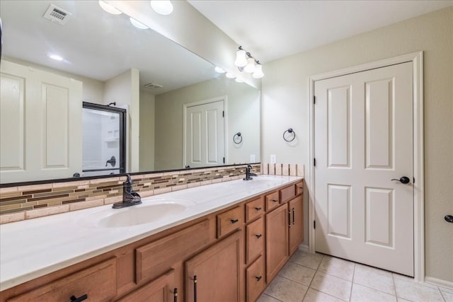 bathroom with tile patterned floors, a shower with shower door, decorative backsplash, and vanity