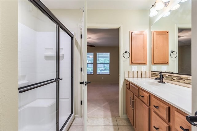 bathroom with tile patterned floors, backsplash, an enclosed shower, and vanity