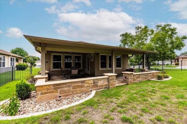 back of house featuring a lawn and a patio area