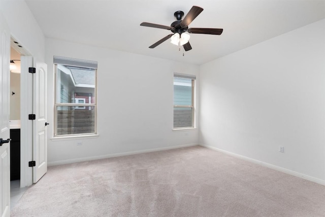 spare room featuring ceiling fan and light colored carpet