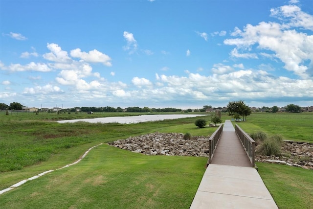 view of home's community with a lawn, a rural view, and a water view