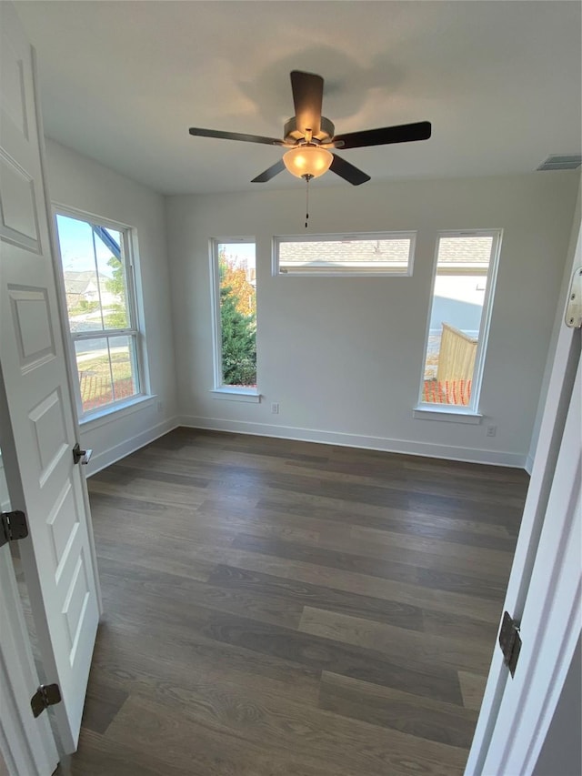 unfurnished room featuring ceiling fan and dark wood-type flooring