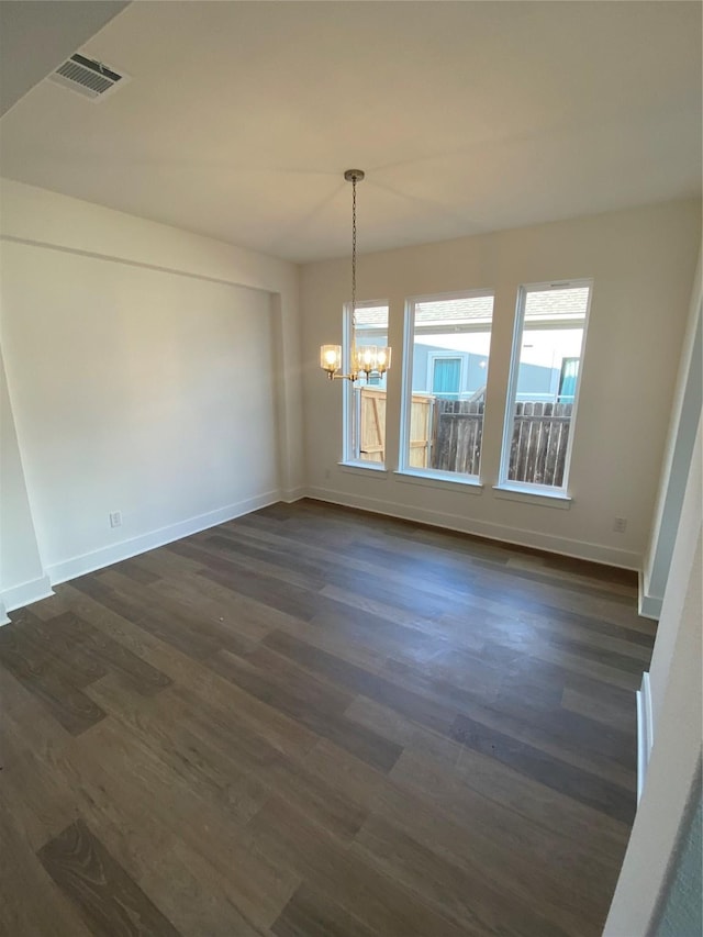 unfurnished dining area with a notable chandelier and dark wood-type flooring