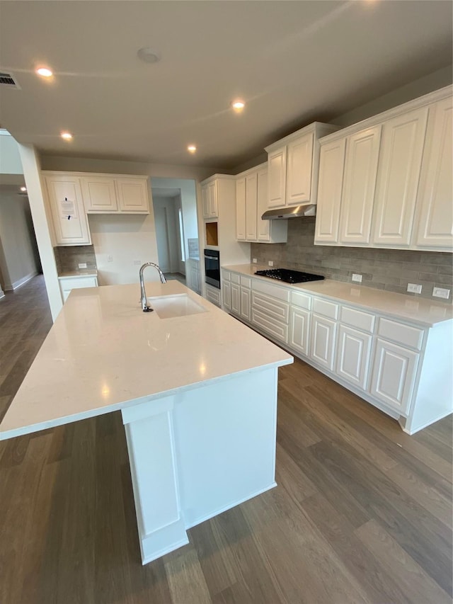 kitchen with sink, a center island with sink, white cabinets, and black appliances