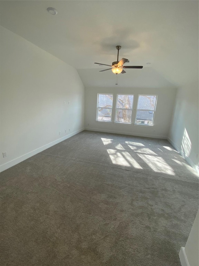 carpeted spare room with ceiling fan and lofted ceiling