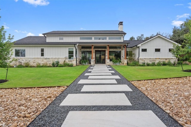 14701 Longbranch Dr, Austin, TX 78734 - back of property with stone siding, french doors, a chimney, and a lawn