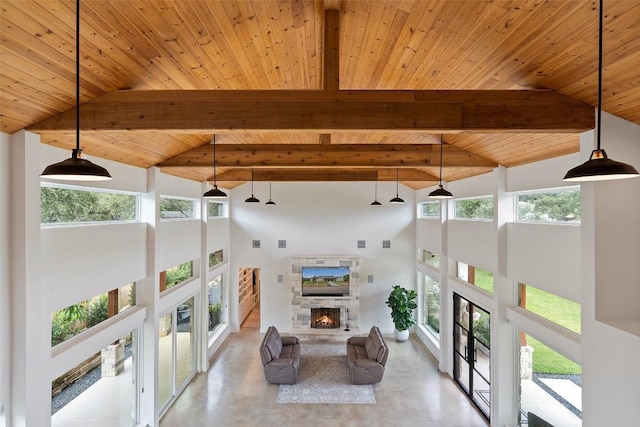 living room with high vaulted ceiling, beamed ceiling, a stone fireplace, and wood ceiling