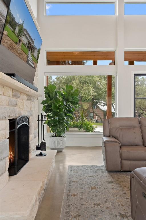 living room with a fireplace and a high ceiling