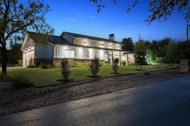 14701 Longbranch Dr, Austin, TX 78734 - modern farmhouse style home with a chimney, a front yard, board and batten siding, a garage, and stone siding
