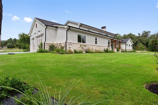 14701 Longbranch Dr, Austin, TX 78734 - view of side of property featuring stone siding, a chimney, a lawn, an attached garage, and driveway