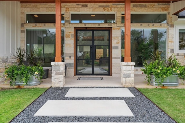 doorway to property featuring stone siding and french doors