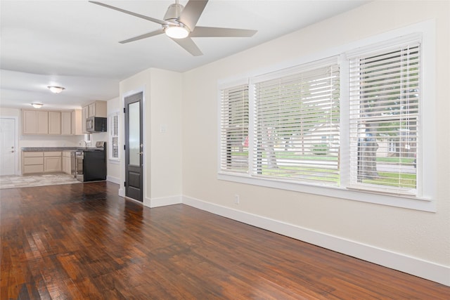 unfurnished living room with ceiling fan and dark hardwood / wood-style floors