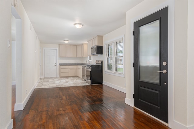 kitchen featuring cream cabinets, stainless steel appliances, and dark hardwood / wood-style floors