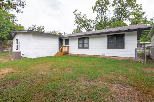 back of house with central AC and a yard