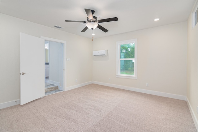 carpeted empty room featuring a wall mounted AC and ceiling fan