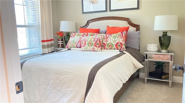 bedroom with light carpet and multiple windows