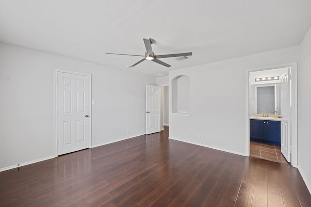 unfurnished bedroom featuring dark hardwood / wood-style flooring, connected bathroom, sink, and ceiling fan