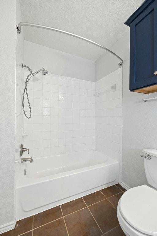 bathroom featuring tiled shower / bath combo, a textured ceiling, toilet, and tile patterned flooring