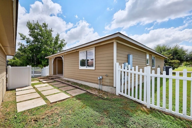 view of side of home featuring a lawn and a patio