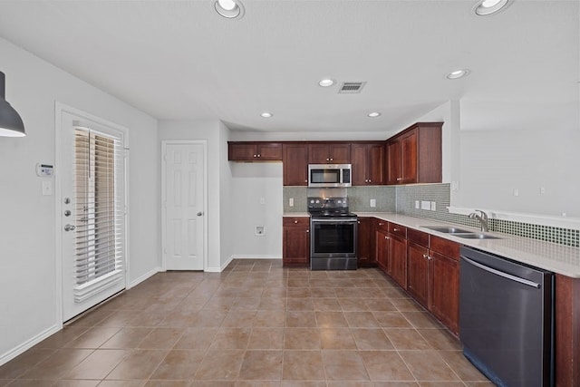 kitchen with light tile patterned floors, tasteful backsplash, stainless steel appliances, and sink