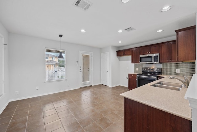 kitchen with light tile patterned floors, sink, decorative backsplash, hanging light fixtures, and appliances with stainless steel finishes