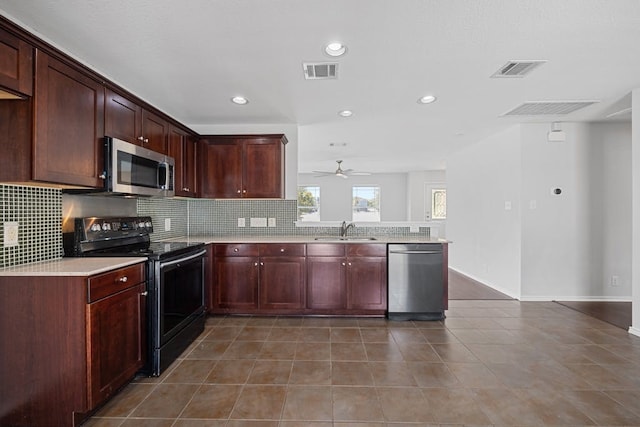 kitchen with tile patterned flooring, appliances with stainless steel finishes, sink, ceiling fan, and tasteful backsplash