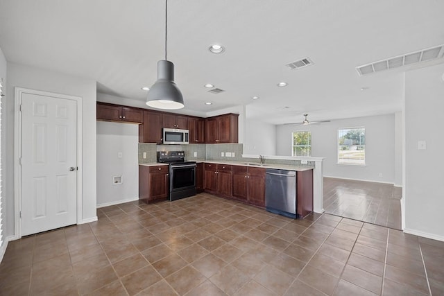 kitchen featuring light wood-type flooring, tasteful backsplash, decorative light fixtures, ceiling fan, and appliances with stainless steel finishes