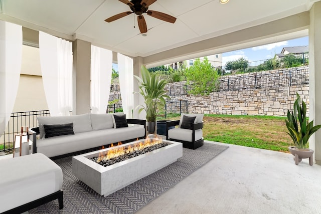 view of patio / terrace featuring ceiling fan and an outdoor living space with a fire pit