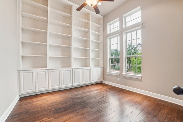 empty room featuring built in features, ceiling fan, and dark hardwood / wood-style floors