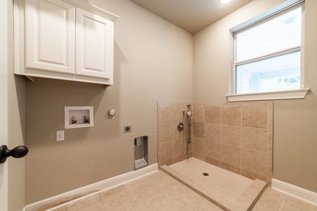 clothes washing area featuring washer hookup, cabinets, gas dryer hookup, electric dryer hookup, and light tile patterned floors