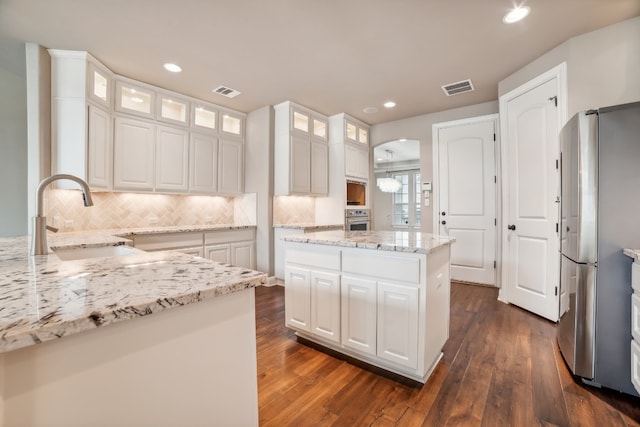 kitchen with a center island, white cabinets, sink, dark hardwood / wood-style flooring, and appliances with stainless steel finishes