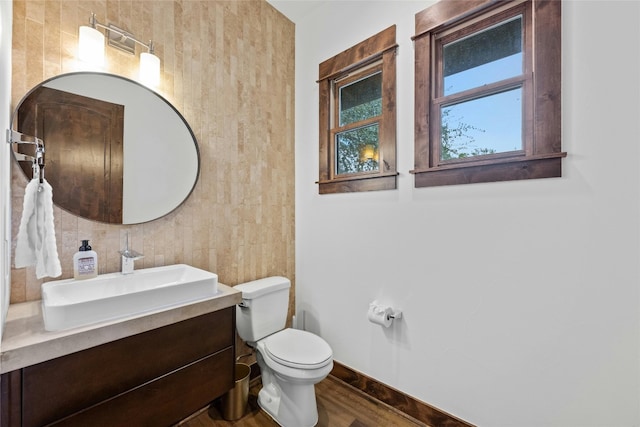 bathroom with vanity, toilet, and hardwood / wood-style flooring