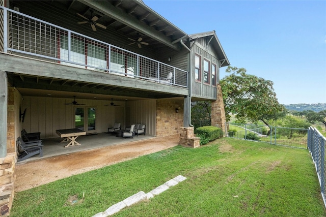 rear view of house featuring a balcony, a yard, ceiling fan, and a patio